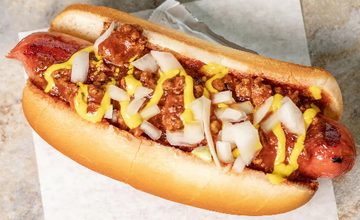 A chili coney dog with mustard and diced onions
